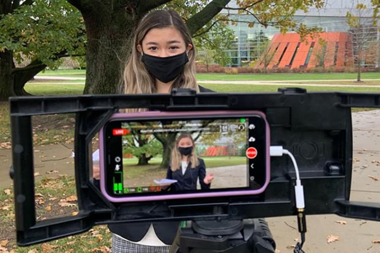 student filming on location