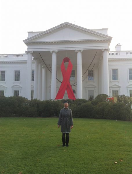 Loewe on the North Portico of the White House in front of a giant red AIDS ribbon put on display by the Obama Administration in honor of World AIDS Day in 2012.