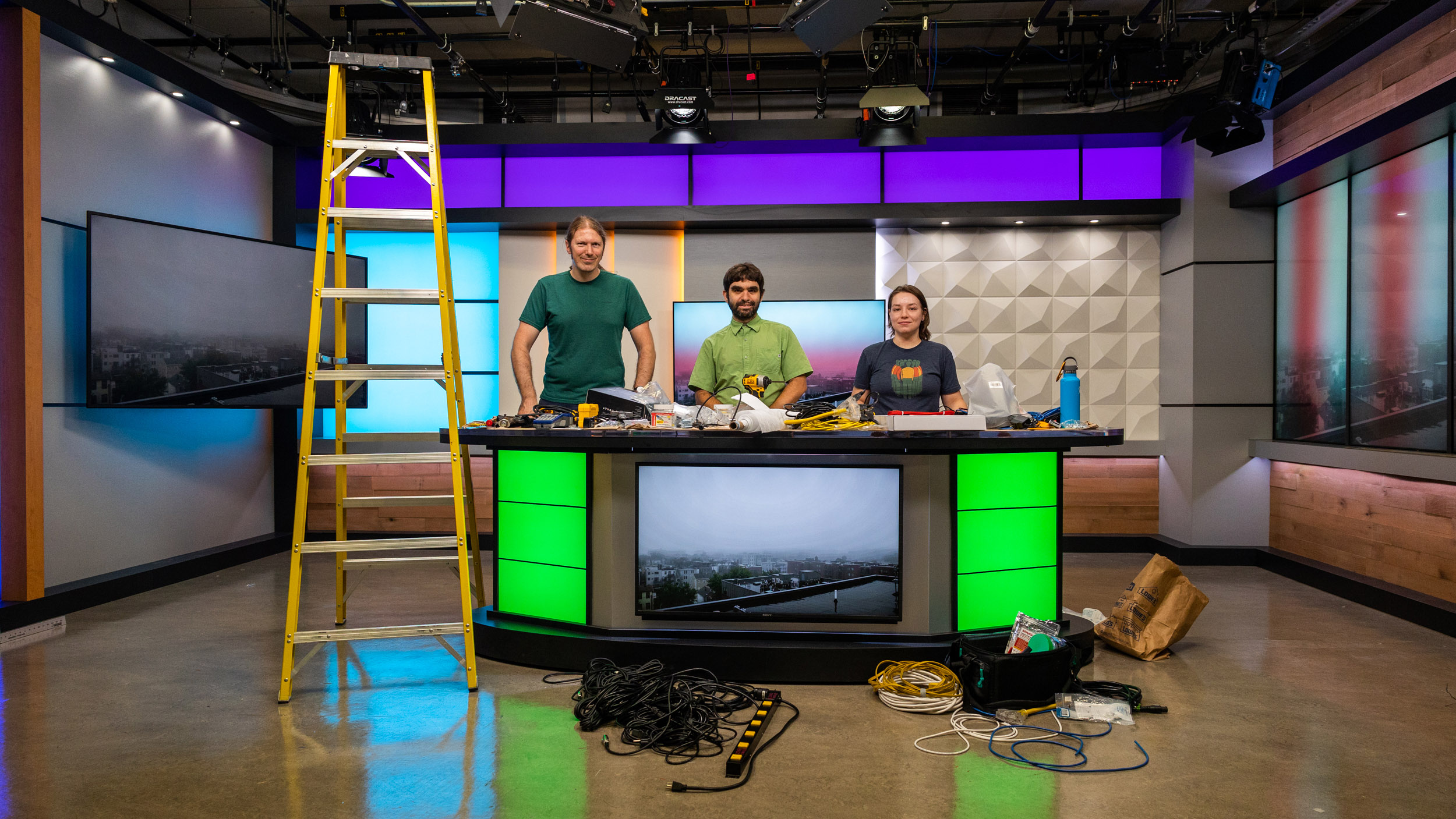 Tristan Olly (lead studio engineer), Jake Kassen (technical operations manager) and Emma Picht (COM ’23) (media technician) pose at the new anchor desk in Studio West. Photo by Guramar Lepiarz.