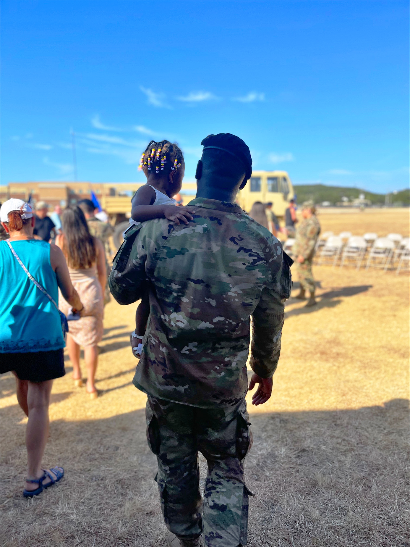 a soldier walks while carrying a young girl